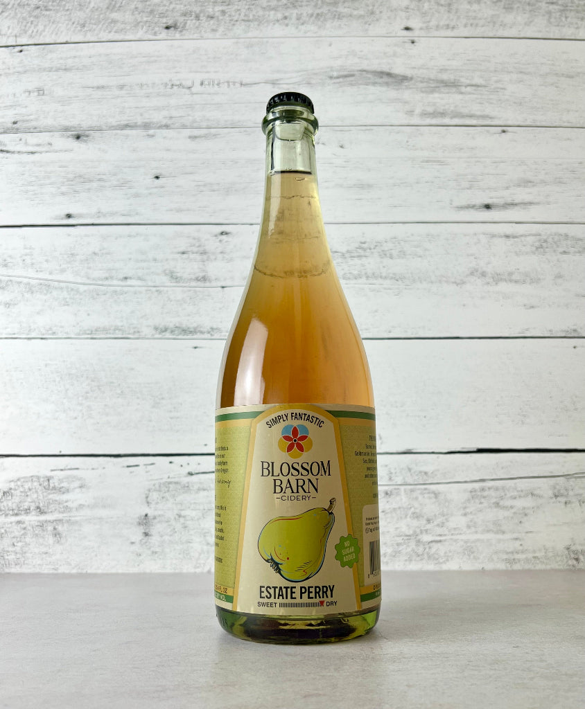 Photo of a 750 mL Bottle of Blossom Barn Perry on a white surface with a white wooden background