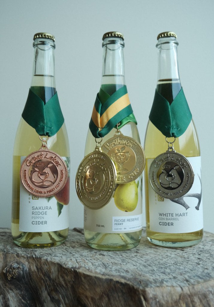 3-bottles of 750 mL cider from Nashi Orchards, with Great Lakes International Cider and Perry (GLINTCAP) award medals hanging on the neck of each bottle