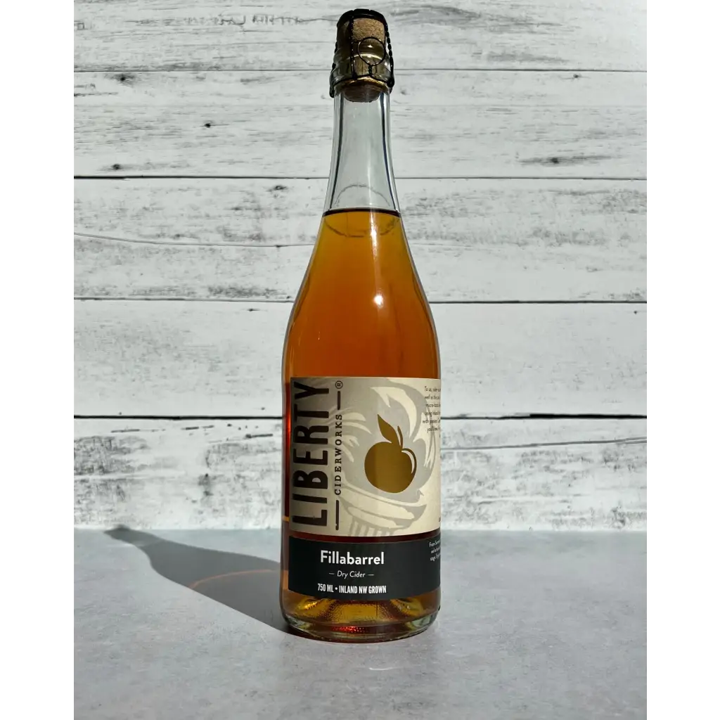 750 mL clear glass bottle of amber hued Liberty Ciderworks Fillabarrel Dry Cider