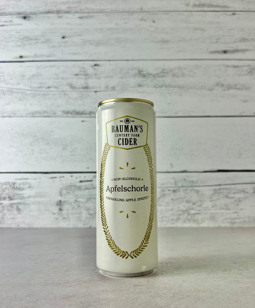 12 oz Can of Bauman's Non-Alcoholic Cider Apfelschorle - sparkling apple spritz with a white wooden background
