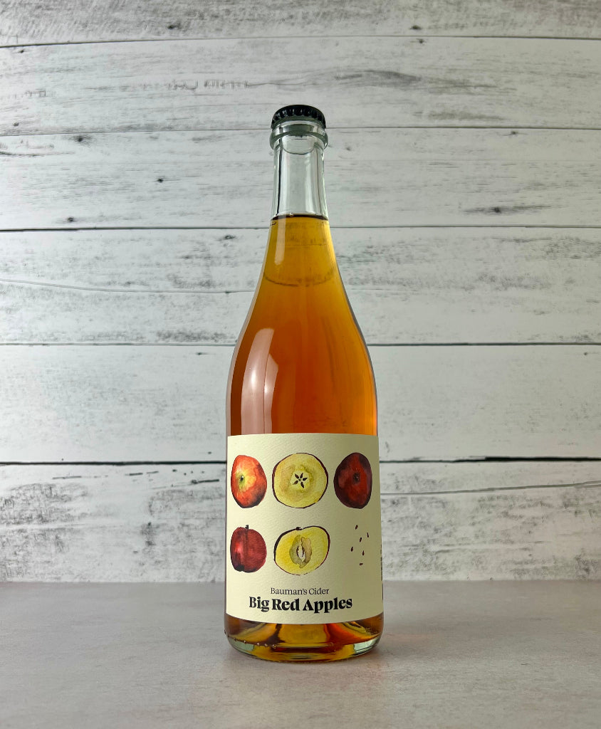 Photo of a 750 mL Bottle of Bauman's Cider Big Red Apples cider with a white wooden background