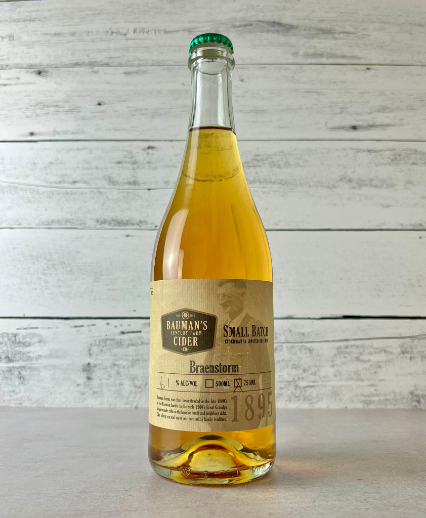Photo of a 750 mL Bottle of Bauman's Cider Braenstorm Small Batch Cider on a white wooden background