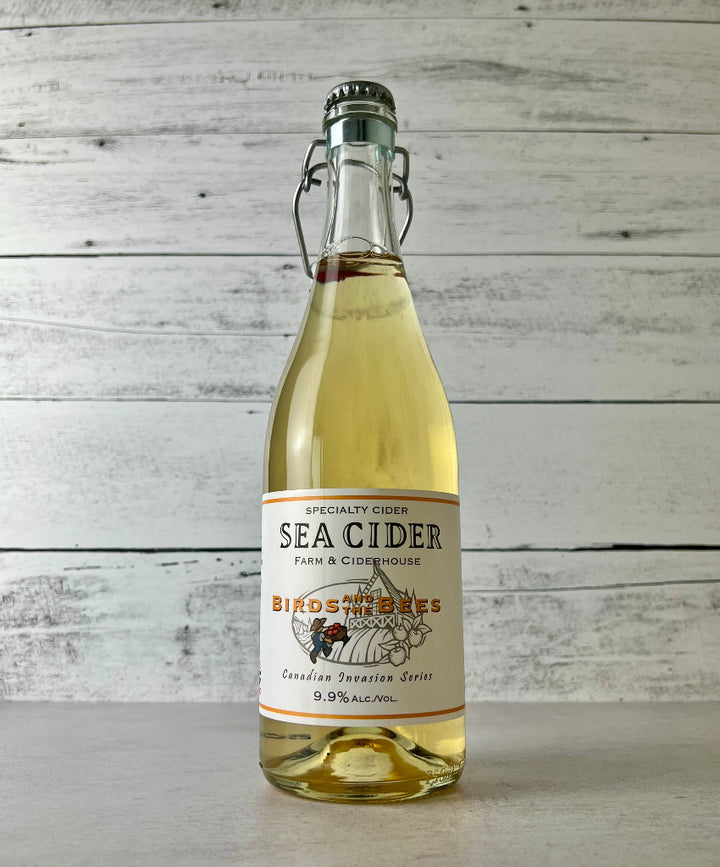 Photo of a 750 mL clear glass bottle of Sea Cider Farm and Ciderhouse  Birds and the Bees cider - Canadian Invasion Series 