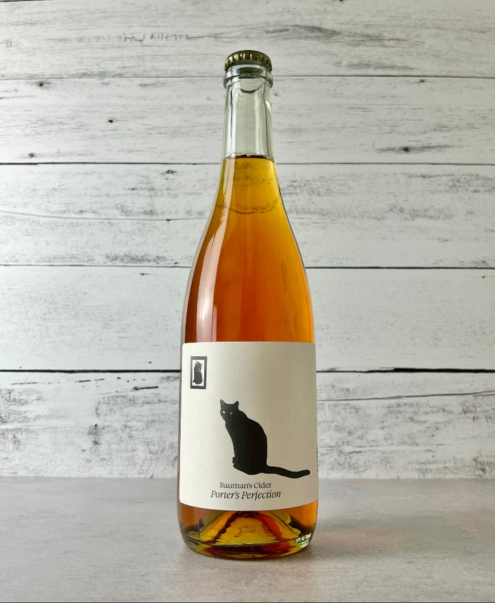Photo of a 750 mL bottle of Bauman's Cider Porter's Perfection. Label is off-white with a black cat