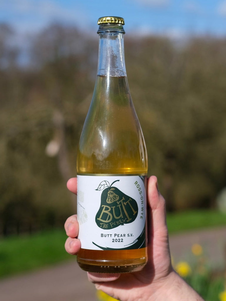 750 mL bottle of Ross-on-Wye Butt Pear S.V. Perry 2022 being held in hand with trees in background
