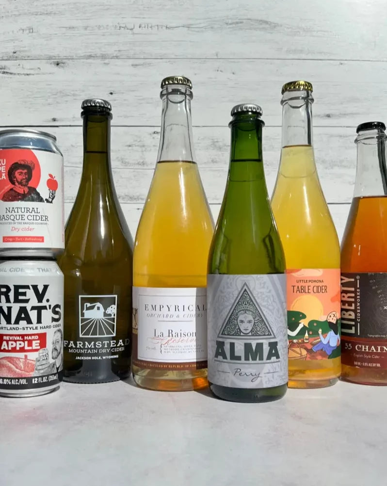 two 12-oz cans of cider (Kupela and Rev Nat's) and five bottles of cider (Farmstead Mountain Dry, Empyrical La Raison, Alma Perry, Little Pomona Table Cider, and Liberty 55 Chain