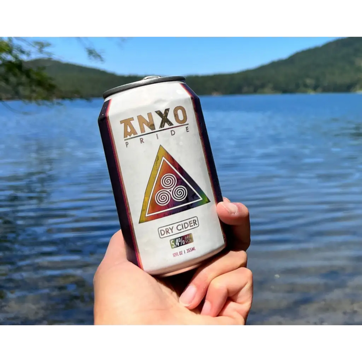 12 oz can of Anxo Pride Dry Cider with lake in background