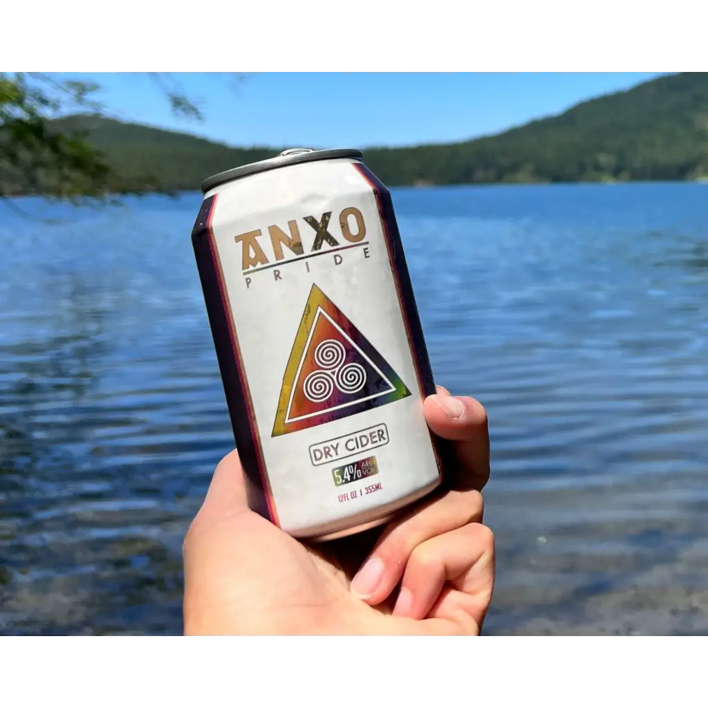 12 oz can of Anxo Pride Dry Cider with lake in background