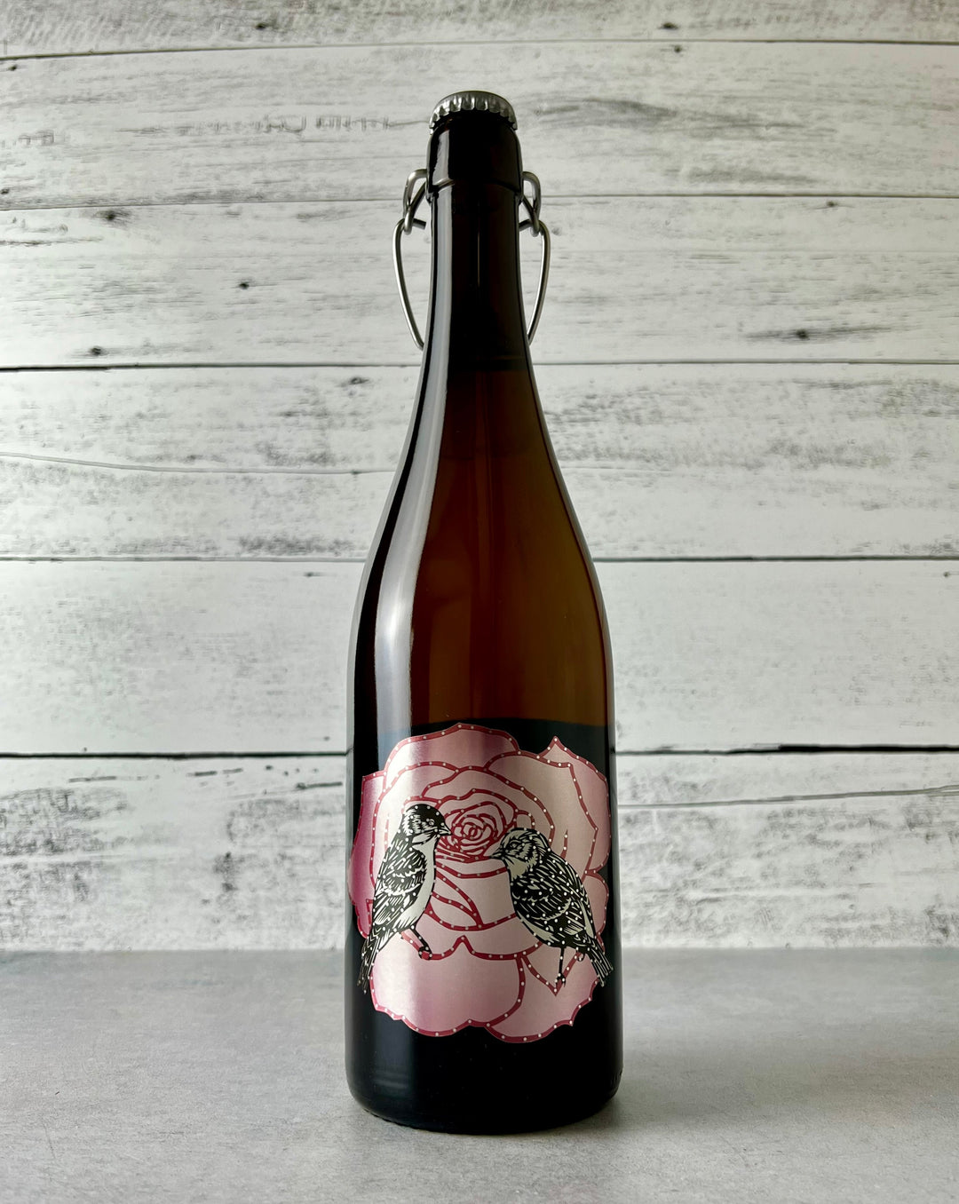 750 mL bottle of Art + Science Cider - Mountain Rose Single Varietal, with artistic label depicting a pink rose with two birds
