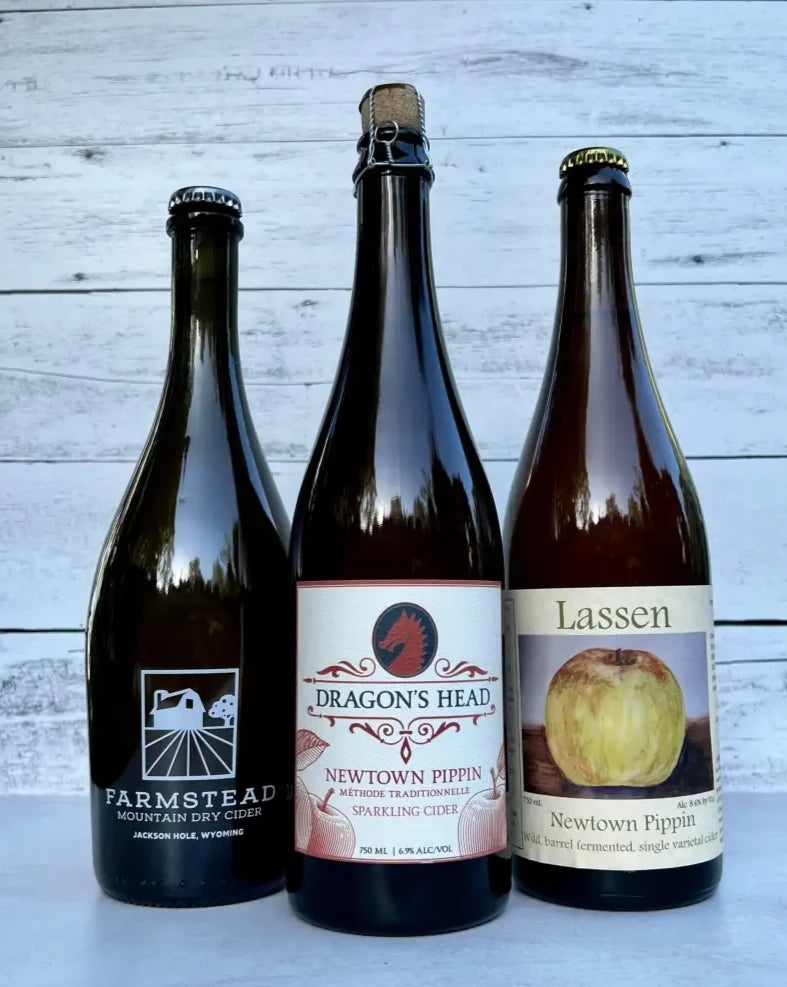 three 750 mL bottles of Newtown Pippin ciders - Farmstead, Dragon's Head, and Lassen