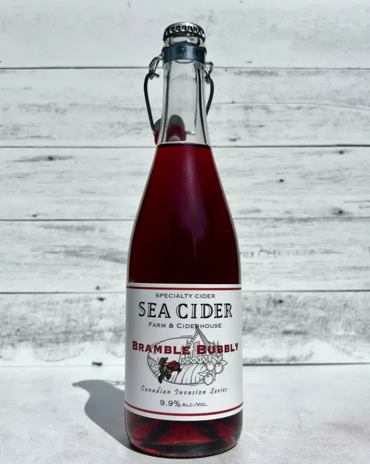 750 mL clear glass bottle of dark pink Sea Cider Farm & Ciderhouse Bramble Bubbly cider