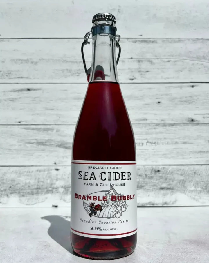 750 mL clear glass bottle of dark pink Sea Cider Farm & Ciderhouse Bramble Bubbly cider
