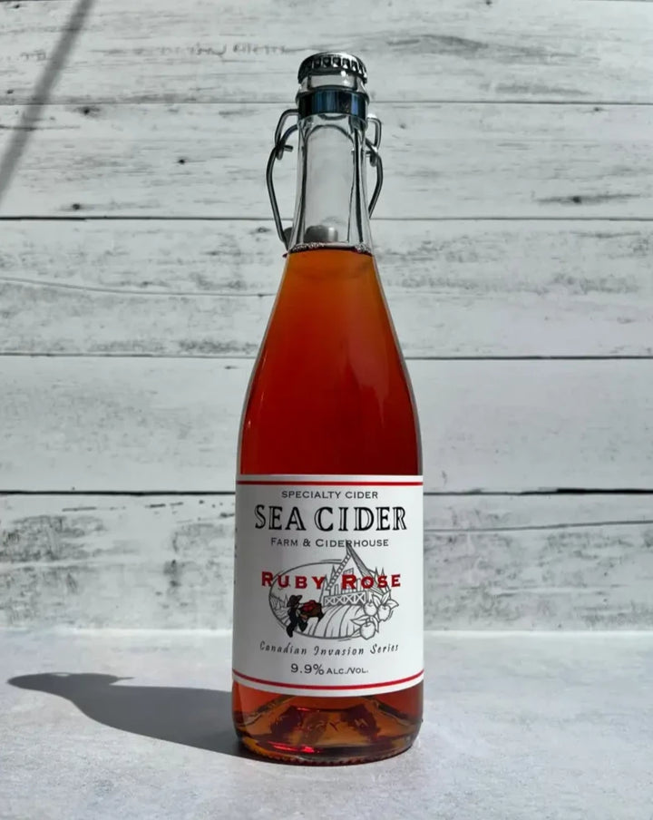 750 mL clear glass bottle of bright pink colored Sea Cider Ruby Rose Canadian Invasion Series cider