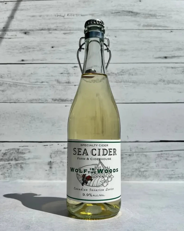 750 mL clear glass bottle of Sea Cider Wolf in the Woods Canadian Invasion Series cider with flip top
